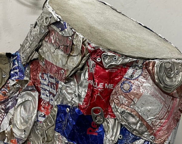 A detail photograph of a sculpture made from crushed soda cans.