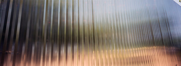 A photograph of a corrugated metal surface with light reflecting off of it.