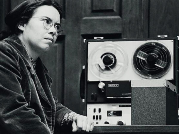 Image of a woman listening to tape on an antique player