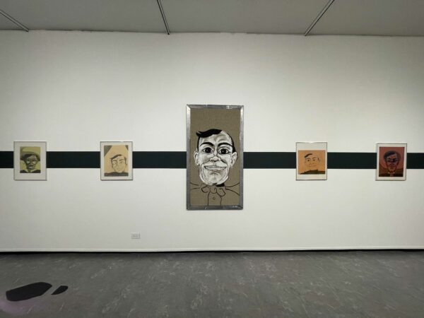 Installation view of cowboy portraits on a wall