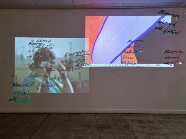 Installation view of two videos and plexiglass text floating over
