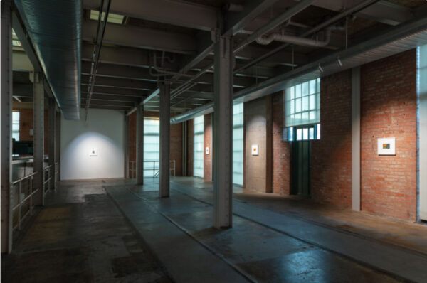 Installation view of small works on brick walls at the Power Station, Dallas