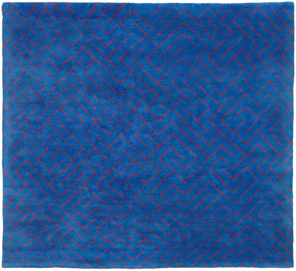 A fabric work by Anni Albers featuring a geometric pattern of red lines on a blue background.