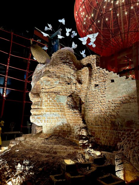 Installation view of a large deity made of brick