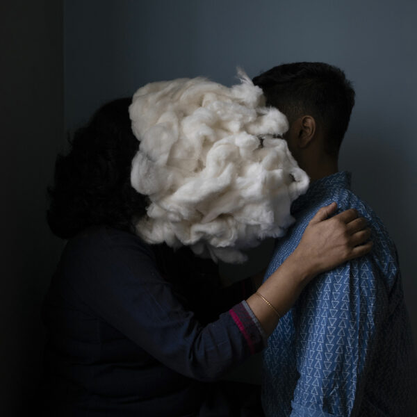 Photo of a man and woman with pillow stuffing in front of their faces