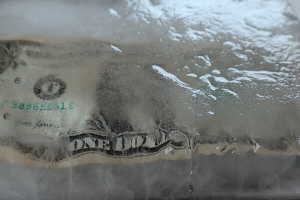 A photograph of a U.S. one dollar bill frozen in ice.