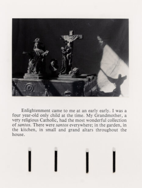 Image of a work with a black and white photo of a cross and saint, text on the bottom, and a row of match sticks