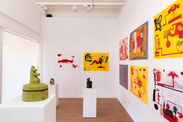 Installation view of works on paper on white walls and ceramics on pedestals