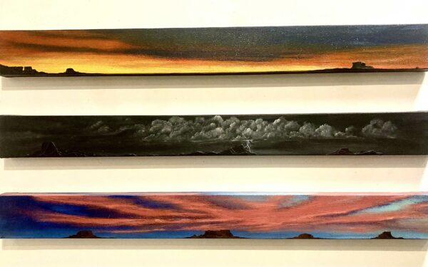 Installation view of three long paintings of horizons
