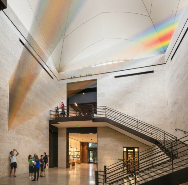 A photograph of a site-specific installation made with various colors of thread by Gabriel Dawe.