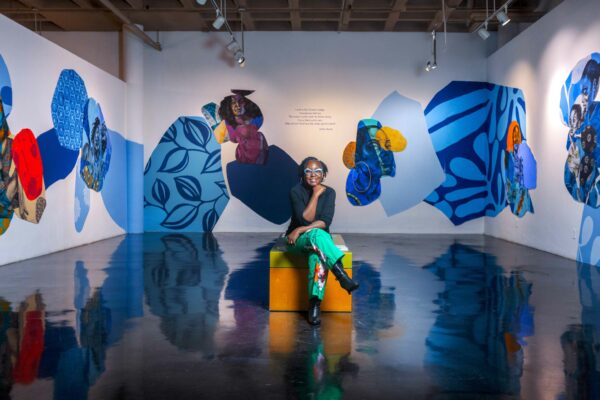 Photo of the artist Delita Martin sitting in her exhibition