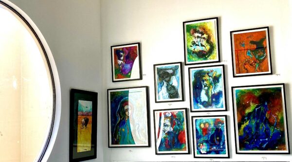 Interior of a gallery wall with figurative paintings hanging
