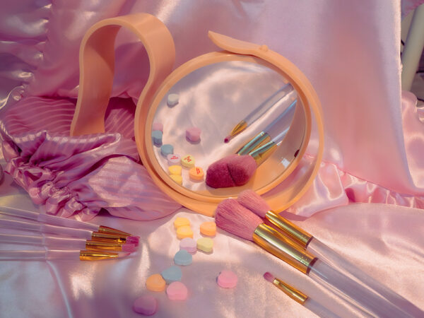 Digital photo of a candy colored mirror and makeup brushes
