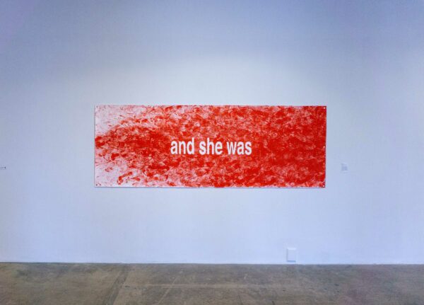 Image of the words "and she was" written in white typeface agains a fading red backdrop