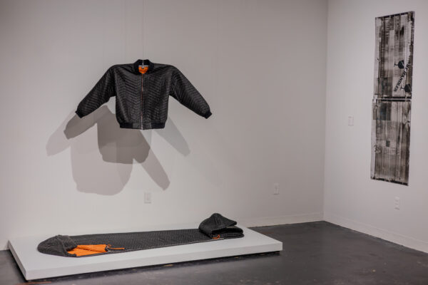 Installation view of garments made by art handlers from shipping blankets