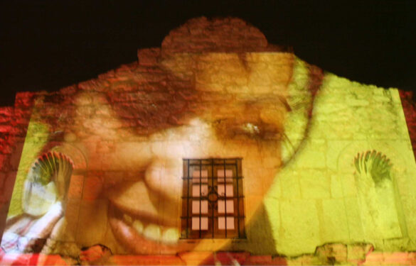 Photo of the portrait of a woman projected onto the alamo