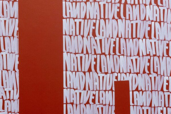 installation view of the word "Motherland" written with white letters that spell "Native Land"
