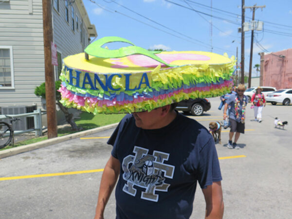 A man wearing a pinata chancla hat