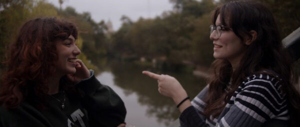 Film still of two teenagers facing each other talking