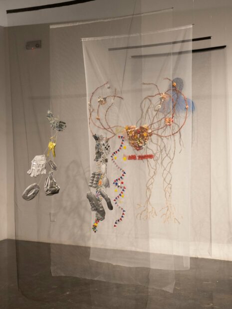 Image of layers of embroidered mesh hanging from the celing