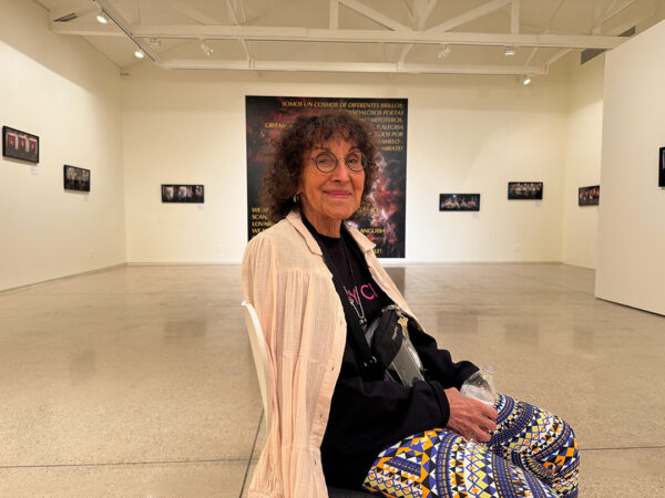 A photograph of artist Celia Álvarez Muñoz sitting in a gallery at Ruby City in San Antonio.