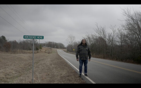 Image of the artist standing on the side of a road