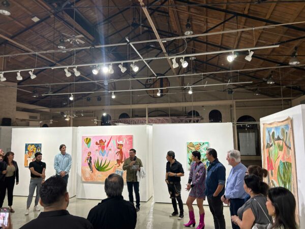 LCA Director talks with visitors in front of Cruz Ortiz paintings