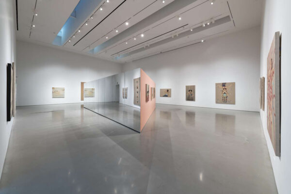 Installation view of two dimensional works on walls with a mirror wall in the center