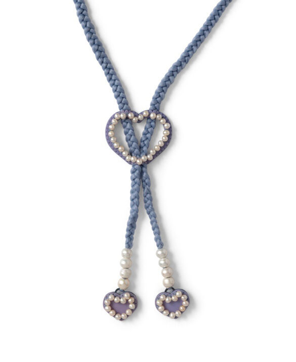 Detail of a light blue bolo tie with white pearls