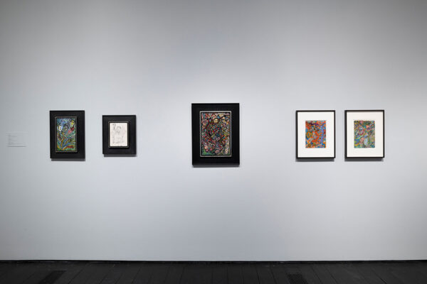 Five abstract paintings of various sizes hang on the wall of the Menil Collection.