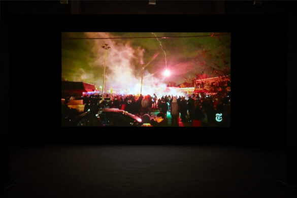 A still image from a video by Arthur Jafa showing a nighttime protest with flares and smoke.