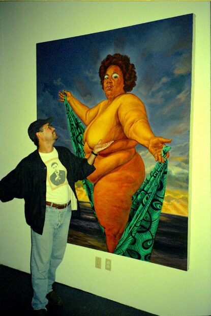 Photo of the artist with his painting of a nude woman