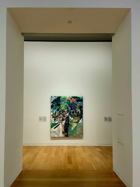 Installation view of a mixed media painting against a white wall
