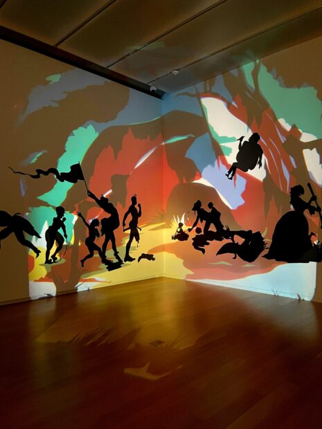Installation view of a Kara Walker piece with painting and antique projector