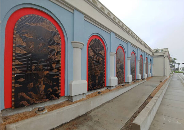 A photograph of the installation of Ben Muñoz's "The Endless Endeavor" panels on the exterior of the Art Center of Corpus Christi.