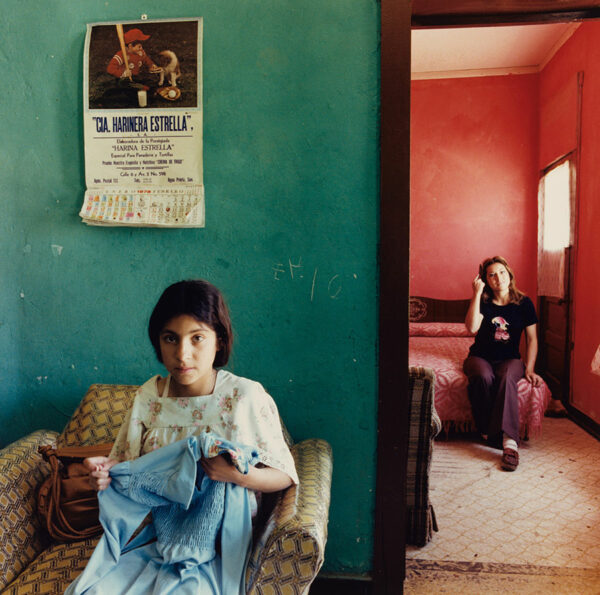 Two women satre into the camera from different rooms in a colorfully painted house.