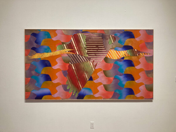 A painting constructed of individual pieces of painted wood depicts an egret in flight against a background of uniformly tiles planes