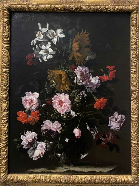 A sixteenth century painting of flowers in a vase before a dark background.