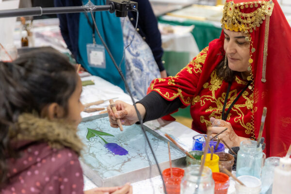 A photograph of an artist demonstrating a painting technique.