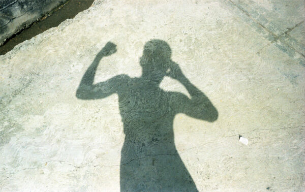 The shadow of the photgrapher is depicted flexing his muscles.