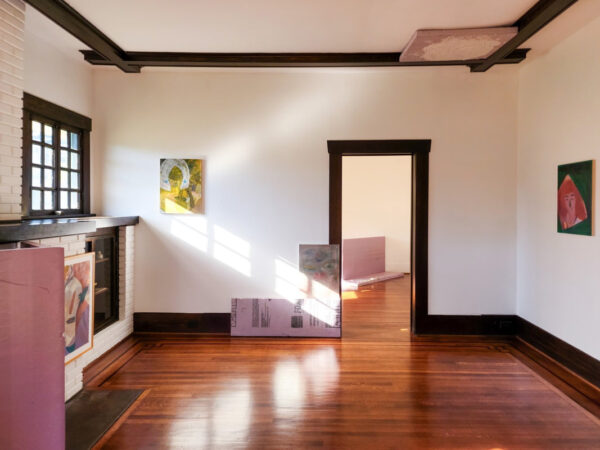 A gallery with sunlight coming in through a window displays paintings in its walls, floor, and ceiling.