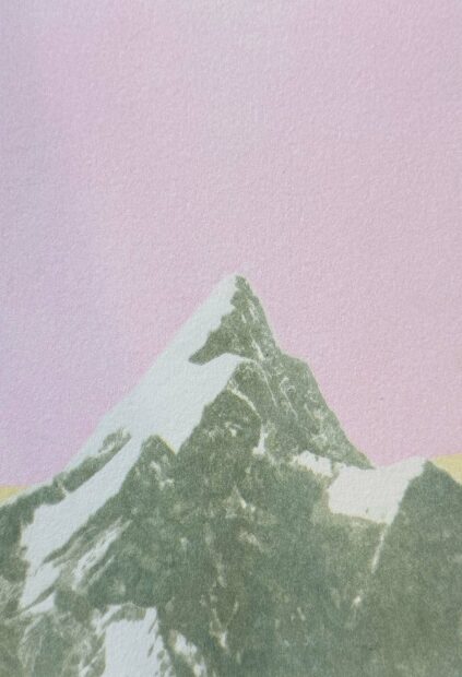 An image of a snow-capped mountain peak, set against a pink sky.