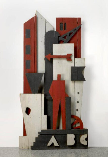 A wooden sculpture consisting of red, white, and black sections.