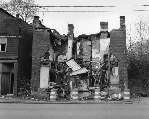 A black and white photograph of a dilapidated building. 