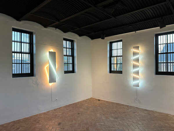 An old jail serves as a gallery with neon artworks on the walls.