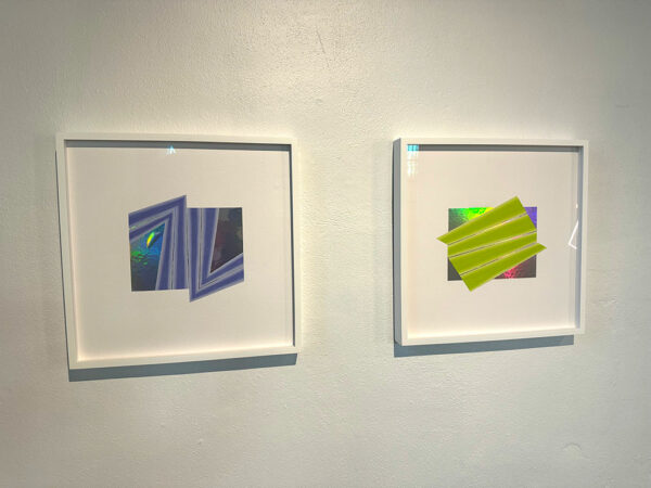 Two framed abstractions hang on the wall of a gallery.