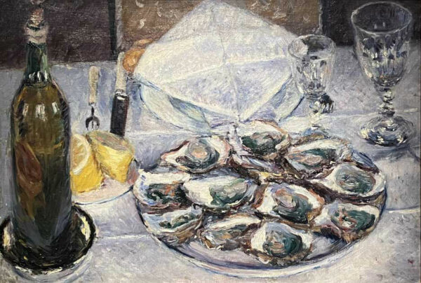 A plate of oysters with a glass, lemons, and a bottle of alcohol atop a table.