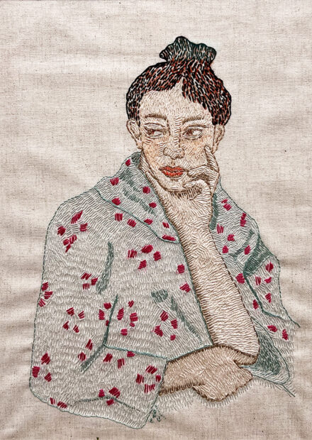 A photograph of an embroidery work by Susie Phillips featuring a figure looking to the side.