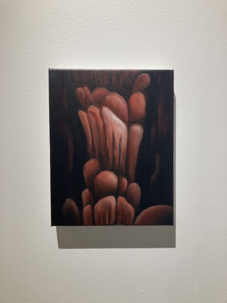 A rectangular painting of rust-colored circular forms stacked on top of one another