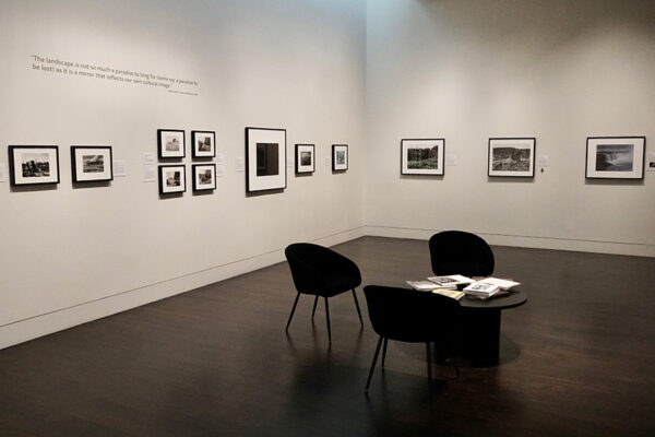 A white-walled gallery with several framed black and white photographs on display.